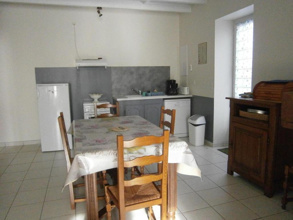 a kitchen with a table and chairs in a room at A lines in Montsoué