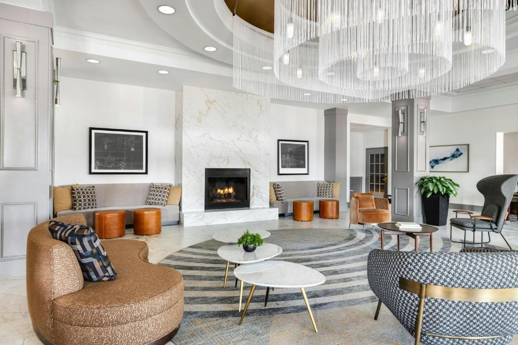 een woonkamer met een open haard en een kroonluchter bij Chicago Marriott Midway in Bedford Park