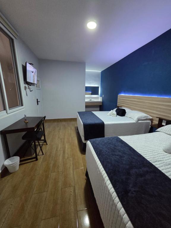a hotel room with two beds and a tv at Casa Sismarro Hotel in Retalhuleu