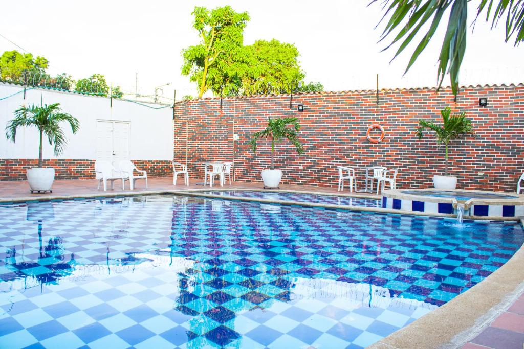 una piscina con suelo de baldosas azules y pared de ladrillo en Hotel Fenix, en Cúcuta