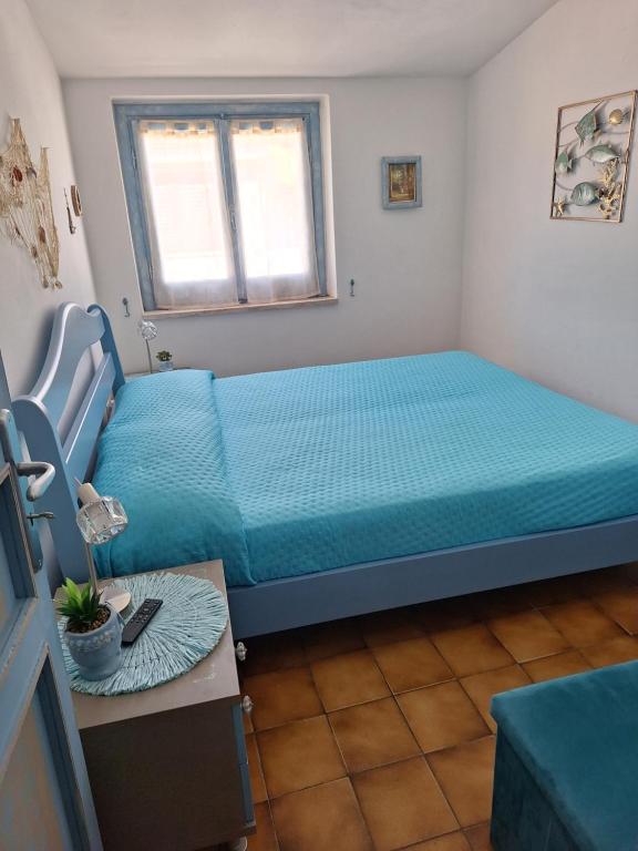 Un dormitorio con una cama con una colcha azul. en Appartamento Oasi Azzurra, en Sellia Marina