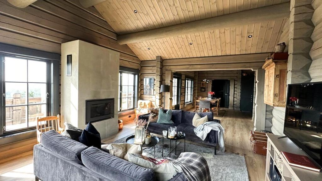 a living room with a couch and a table at Cozy Log Cabin With A View Over Hedmarken in Løten