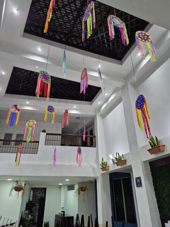a room with colorful kites hanging from the ceiling at Casa Sismarro Hotel in Retalhuleu