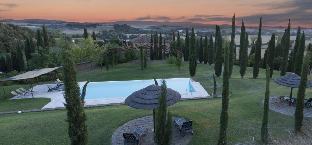 um jardim com piscina e um monte de árvores em Agriturismo Sant'Alfredo em Monteroni dʼArbia