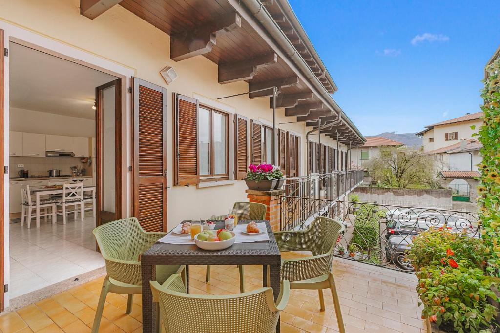 a patio with a table and chairs on a balcony at Petalo Bianco 100m from lake - Happy Rentals in Baveno