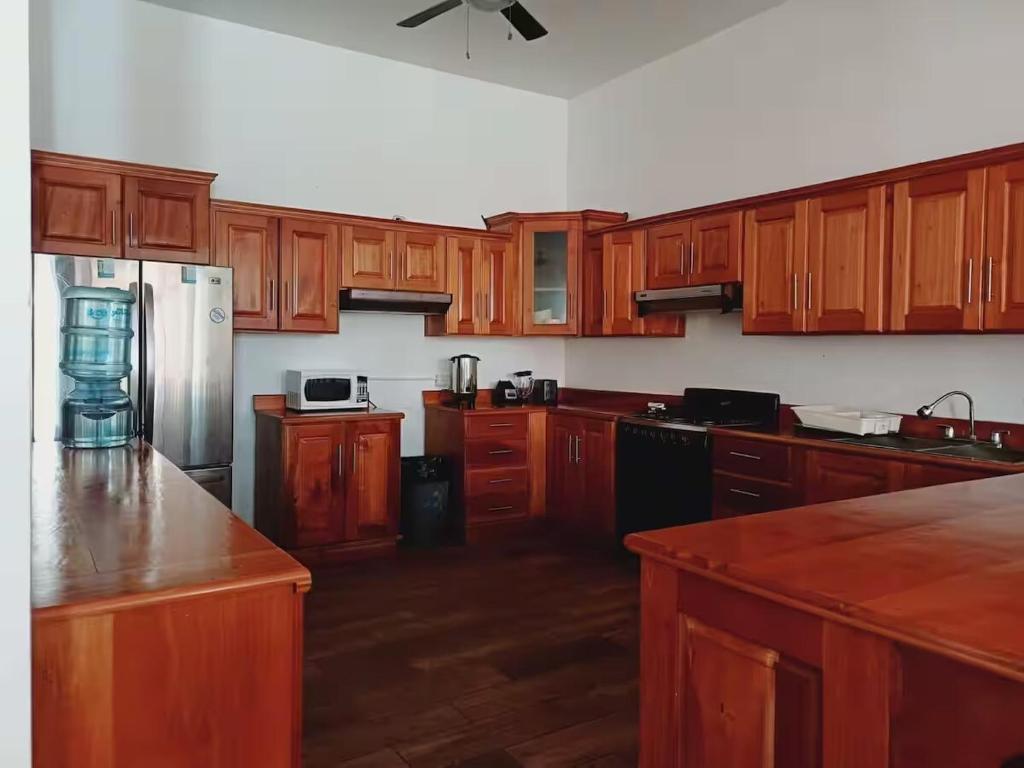 a kitchen with wooden cabinets and stainless steel appliances at Le Mirage GT in Taxisco