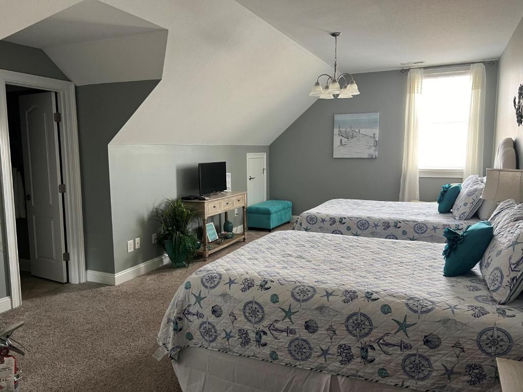 a bedroom with two beds and a flat screen tv at Sutton Room at The Inn, Occano Arnold Palmer Golf 