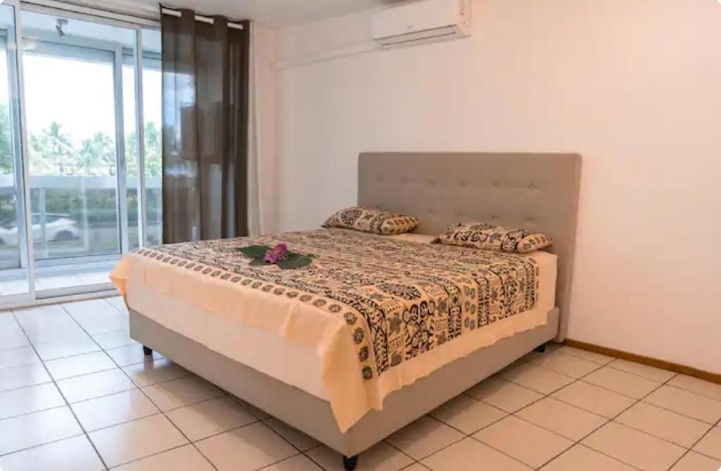 a bedroom with a bed with flowers on it at Studio Teava in Papeete