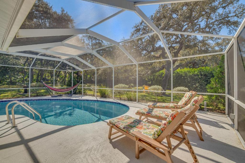 a glass house with a hammock and a pool at Spacious Citrus Hills Home with Pool and Game Room! in Hernando