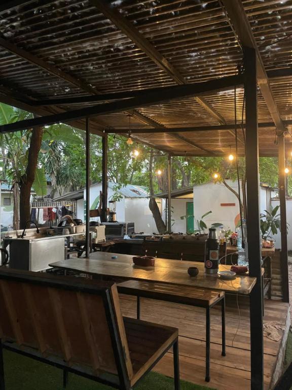 a patio with a wooden table and a wooden bench at Maudie in Santa Teresa Beach