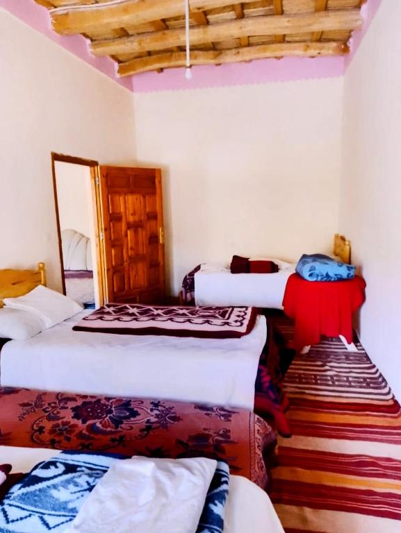 a room with three beds in a room at Riad restaurante Étoile dades Camping in Imdiazene