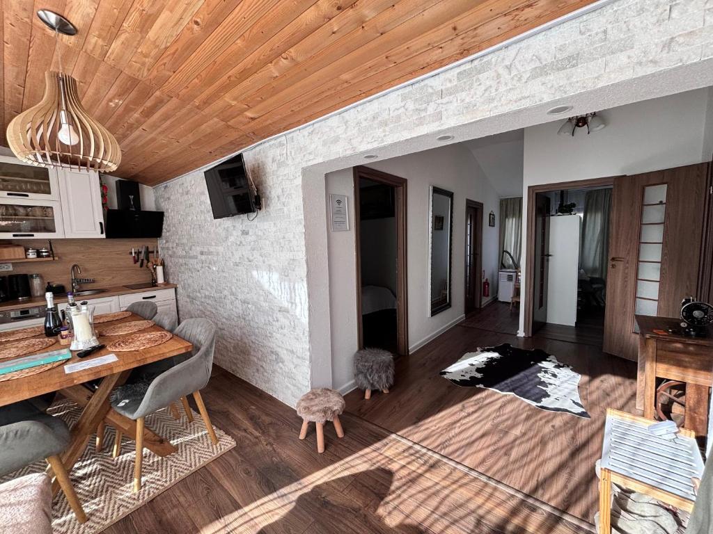 a kitchen and dining room with a wooden ceiling at Cazare La Luiza b in Şura Mare