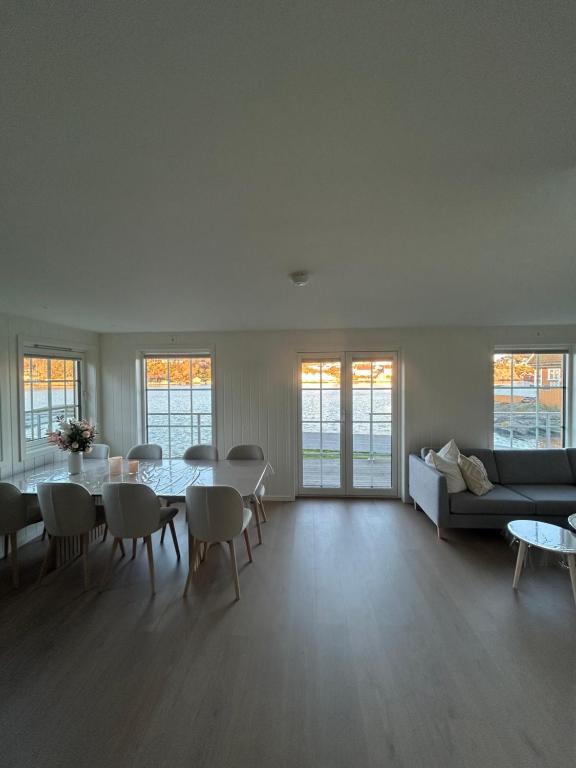 un soggiorno con un divano, un tavolo e delle sedie di 2 hytter i sjøkanten med 20 sengeplasser a Kristiansand