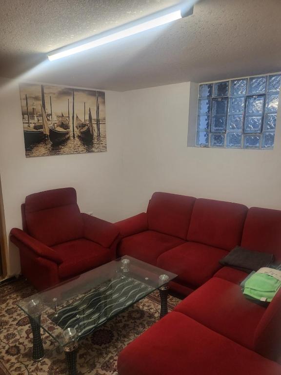 a living room with a red couch and a table at Small apartment suitable for craftsmen in Westerburg