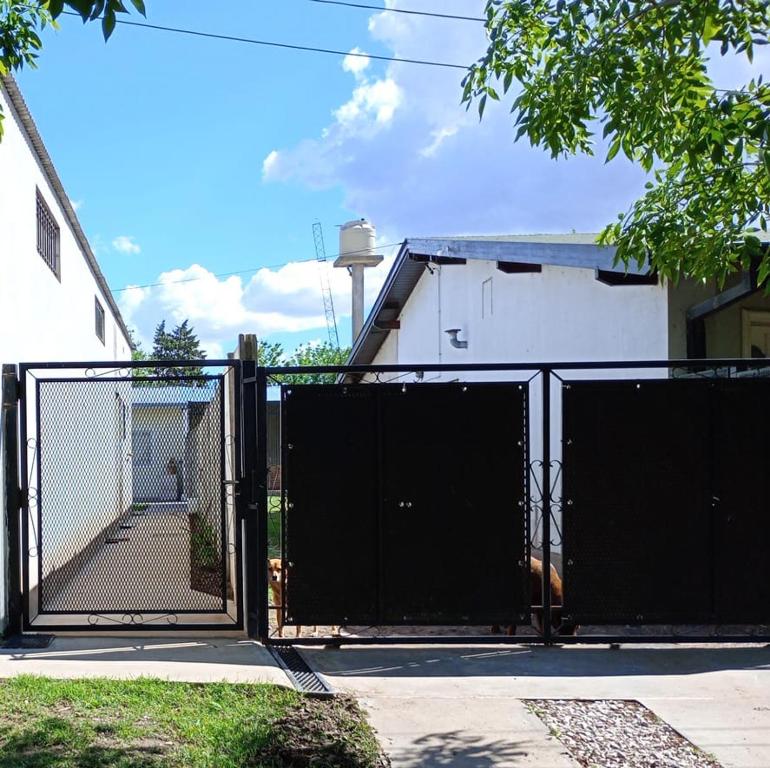 a black gate with a dog behind it at Deptos Los Alerces in General Villegas
