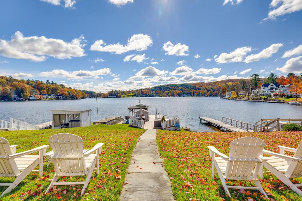 two white chairs and a dock on a lake at Scenic Waterfront Home with Dock on Lake Winola! in Factoryville