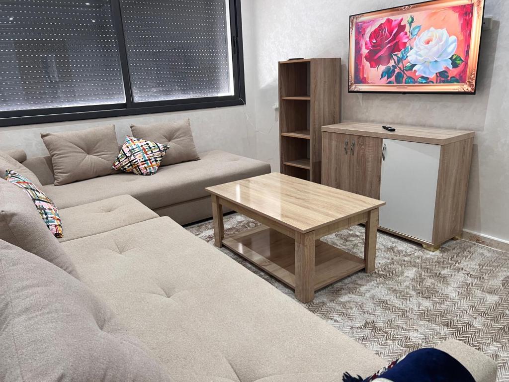 ein Wohnzimmer mit einer Couch und einem Couchtisch in der Unterkunft Appartement laimoun in Anfa