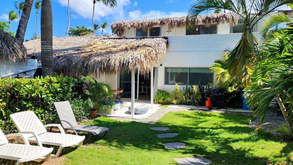 einen Hof mit weißen Stühlen und ein Haus in der Unterkunft BEACH FRONT 3 Bedroom Villa with Pool Sleeps 7 in Las Terrenas