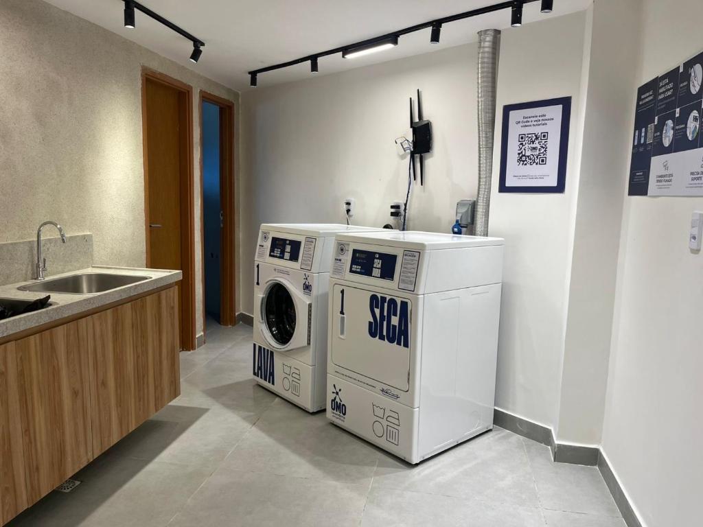 a kitchen with a washing machine and a sink at Flat de luxo em frente ao mar in João Pessoa