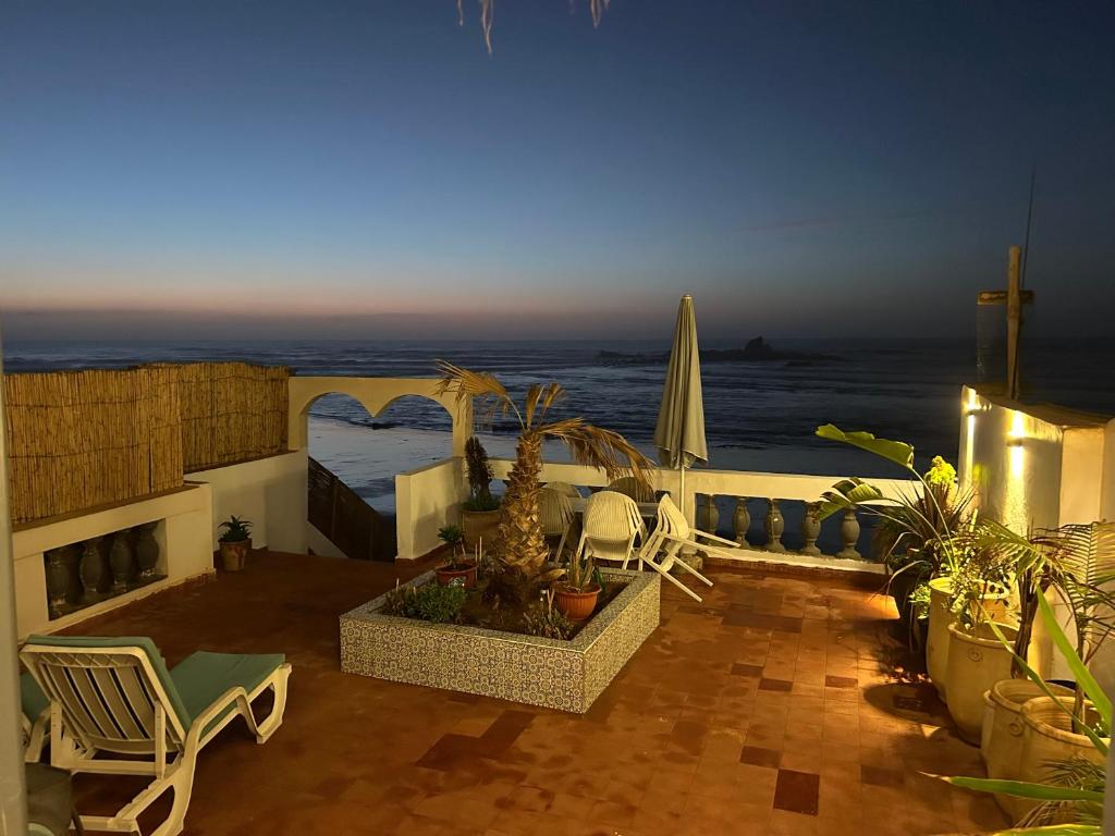 a patio with a view of the ocean at night at À Unique villa, 4 rooms, 5 beds , entire house, LEGZIRA Beach in Sidi Ifni