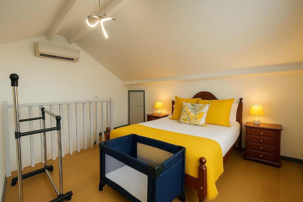 a bedroom with a large bed with yellow pillows at Casa Joao Batista em Machico in Machico