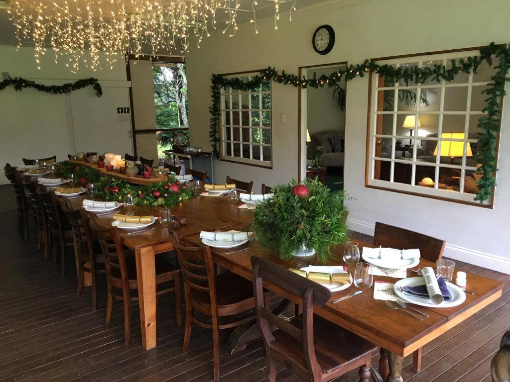 Un comedor largo con una mesa larga y sillas. en Maleny Retreat - Enjoy this Christmas with the Whole family!, en Booroobin