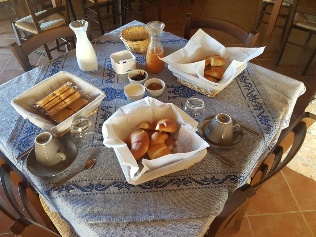einen Tisch mit einem blauen Tischtuch und Körben mit Gebäck in der Unterkunft Agriturismo Gennemara B&B in Perdaxius