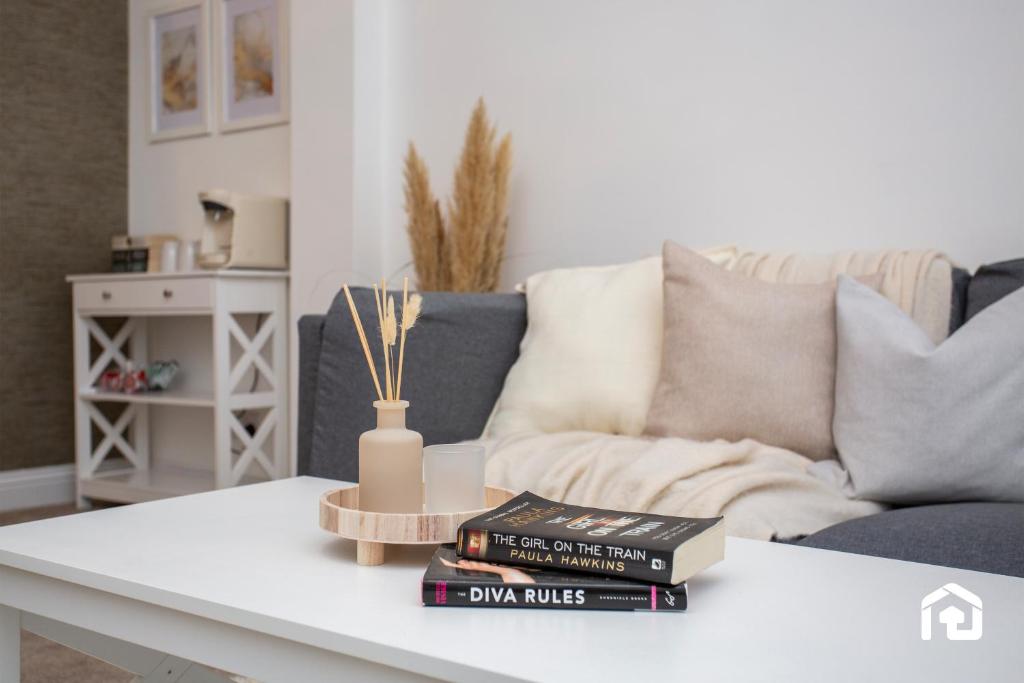 un salon avec une table basse avec des livres et un canapé dans l'établissement Vacant Nests - The Melrose Beach Free Parking, à Woodhorn