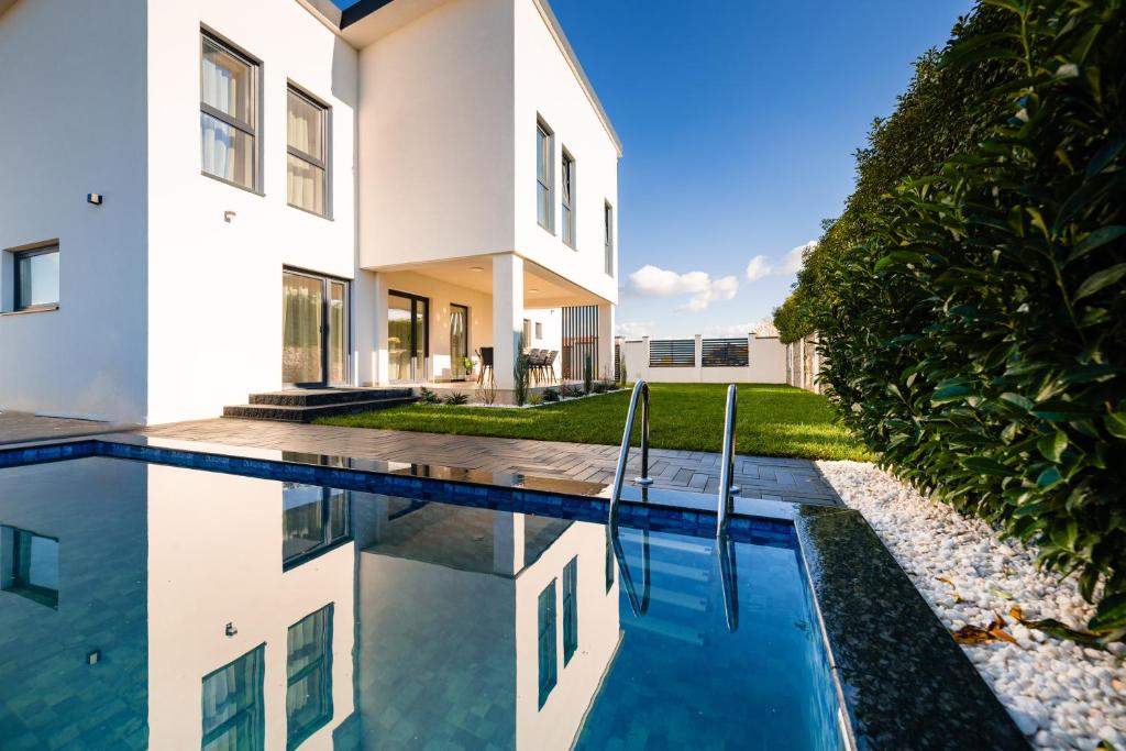 ein Haus mit einem Pool neben einem Haus in der Unterkunft Moonlight City Villa in Alba Iulia