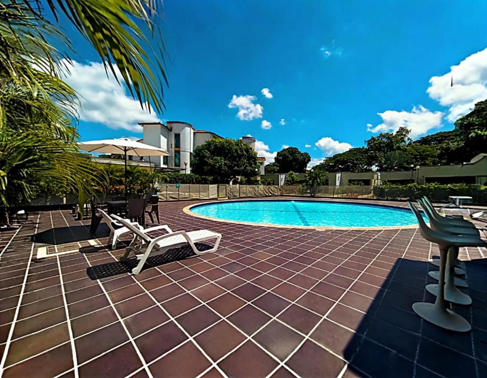 a swimming pool with chairs and a table at Hotel TACALOA INN EXPERIENCE in Ricaurte