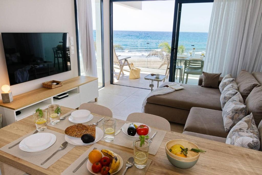 サンアグスティンにあるAmapola Moon - Calidad y disfrute en primera linea de playaの食べ物が置かれたテーブルのあるリビングルーム