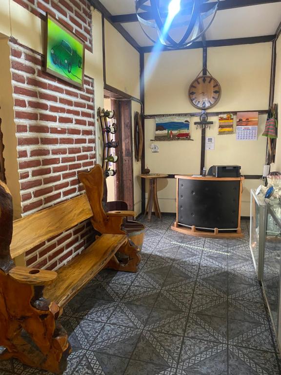 a living room with a bench and a tv at Hostal Centro in Pichilemu