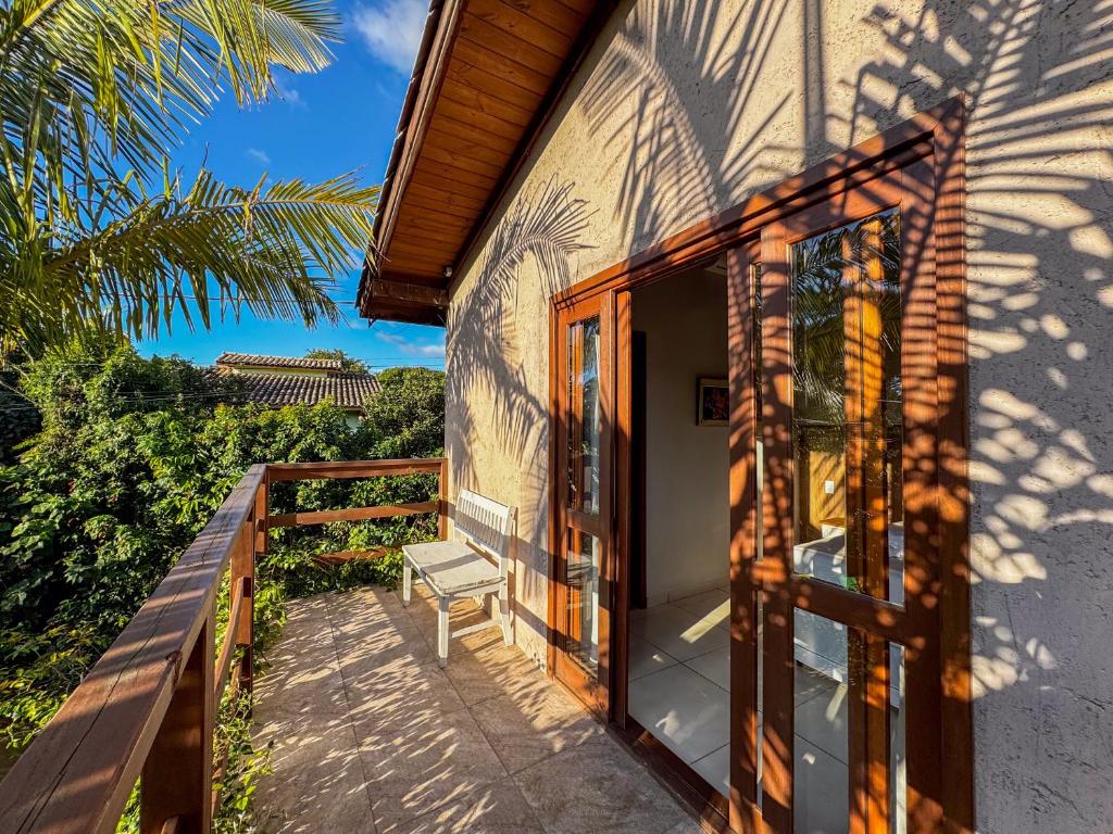 プライア・ド・ローザにあるPousada Lagoa do Rosaの家のバルコニー(ベンチ付)