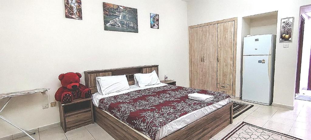 a bedroom with a bed and a refrigerator at Dragon Golden Apartment 2 in Dubai