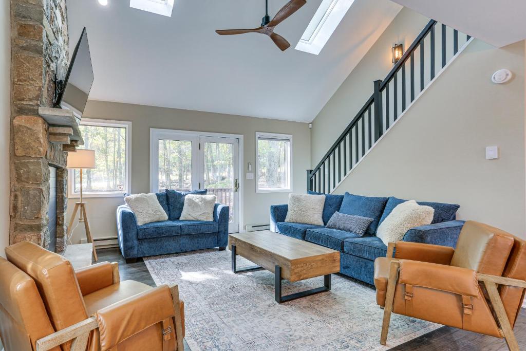 a living room with two blue couches and a table at 6 Mi to Bushkill Falls Secluded Home with Game Room in Saw Creek