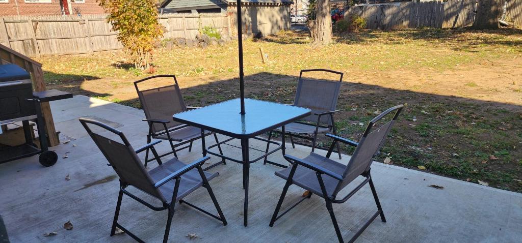 a table with four chairs around it on a patio at The Nook Suite in Hackensack