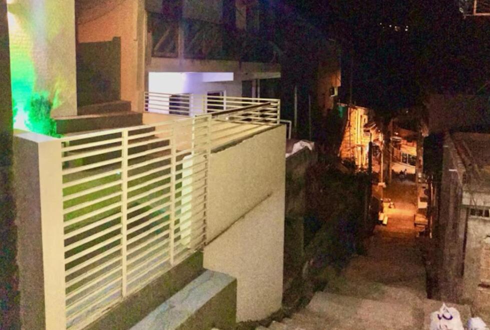 a building with white blinds on the side of a street at Casa Floripes in Cayru