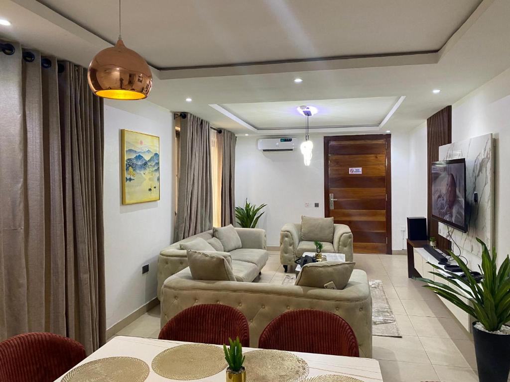 ein Wohnzimmer mit Sofa und Tisch in der Unterkunft Madrid at Invent Apartments in Lekki