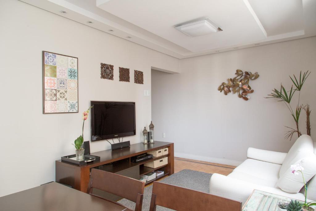 a living room with a white couch and a tv at Apartamento Redenção in Porto Alegre