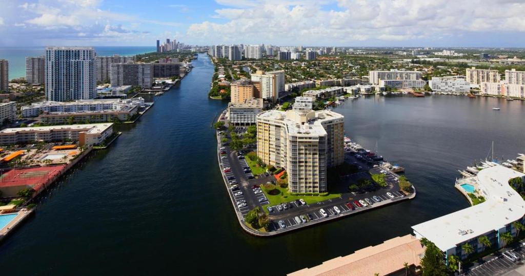 an aerial view of a city with a river and buildings at Hallandale Urban Rooms in Hallandale Beach