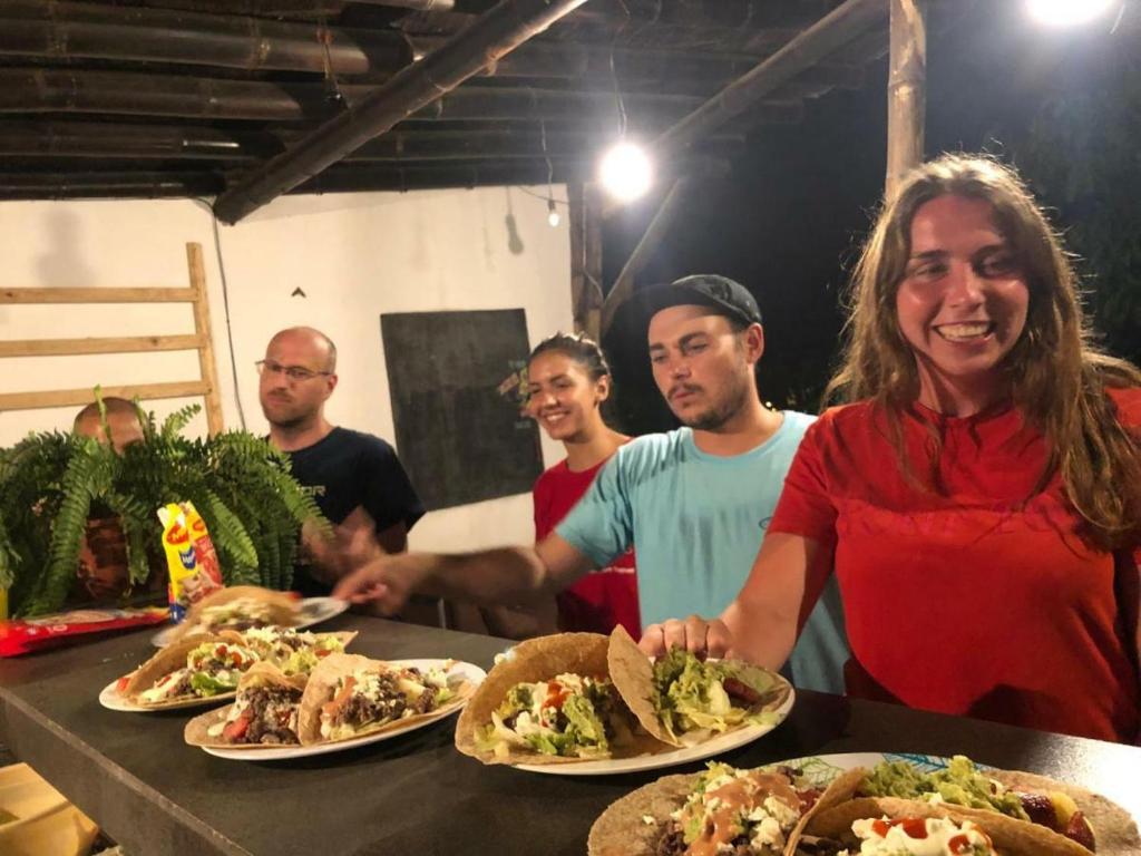 una mujer parada frente a una mesa con platos de comida en Kiwi Home Hostel, en Montañita