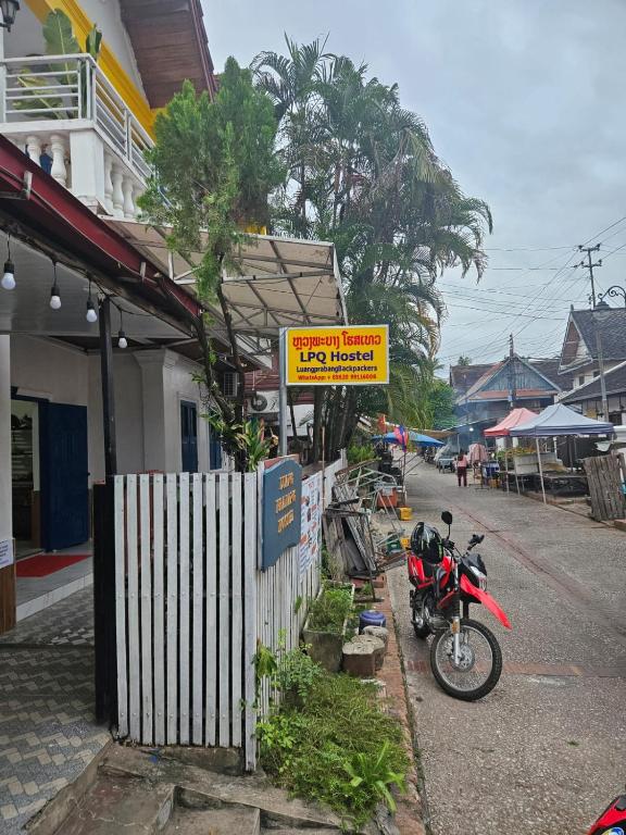 una motocicletta parcheggiata sul ciglio di una strada di LPQ Hostel a Luang Prabang