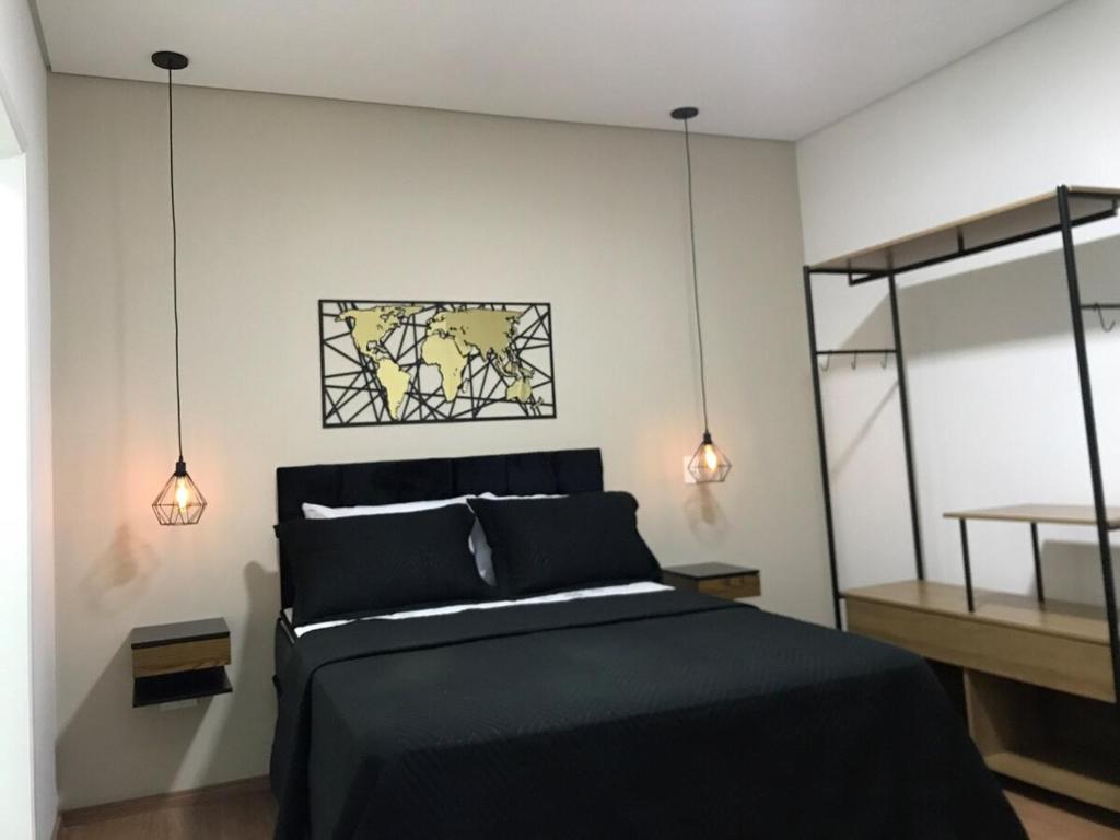 a bedroom with a black bed with two lights at Apartamento Maravilhoso para Casal em São Roque in São Roque