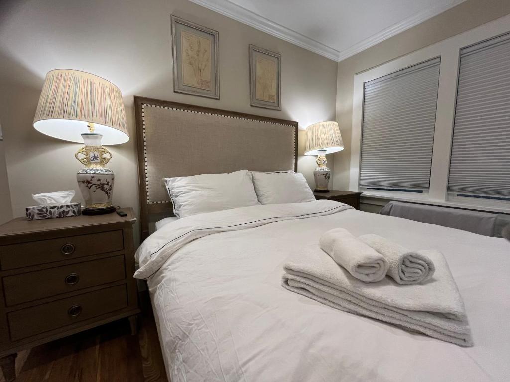 a bedroom with a bed with towels on it at Vancouver West Shaughnessy Maison in Vancouver