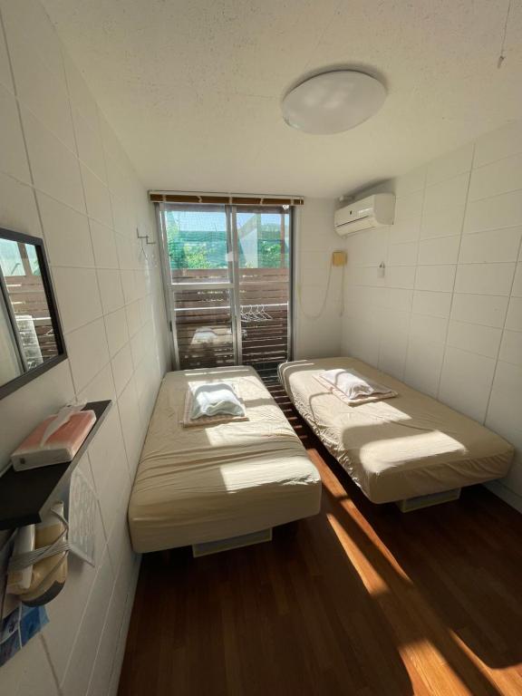 座間味村にあるLagoon315の窓のある小さな部屋にベッドが2つある