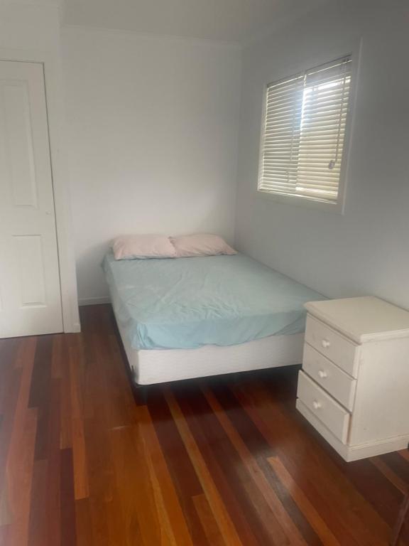 a small bedroom with a bed and a dresser at scarborough QLD private accommodation E in Redcliffe