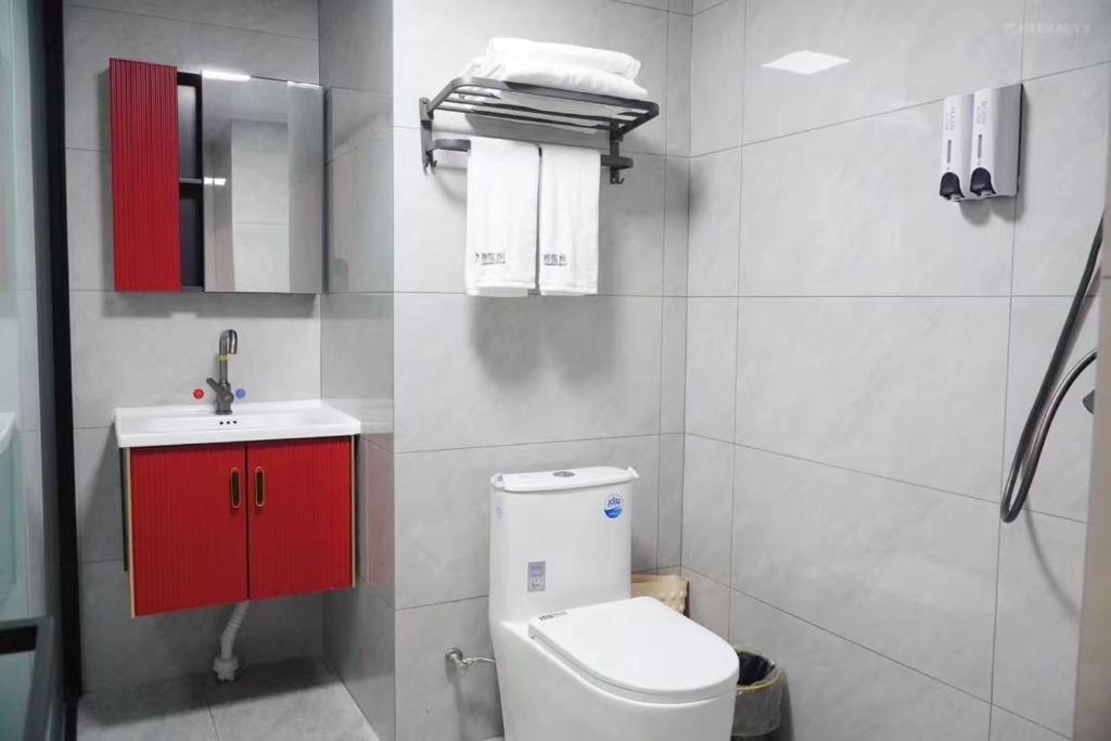 a bathroom with a toilet and a sink and a red cabinet at Happy Bear Youth Hostel in Beijing