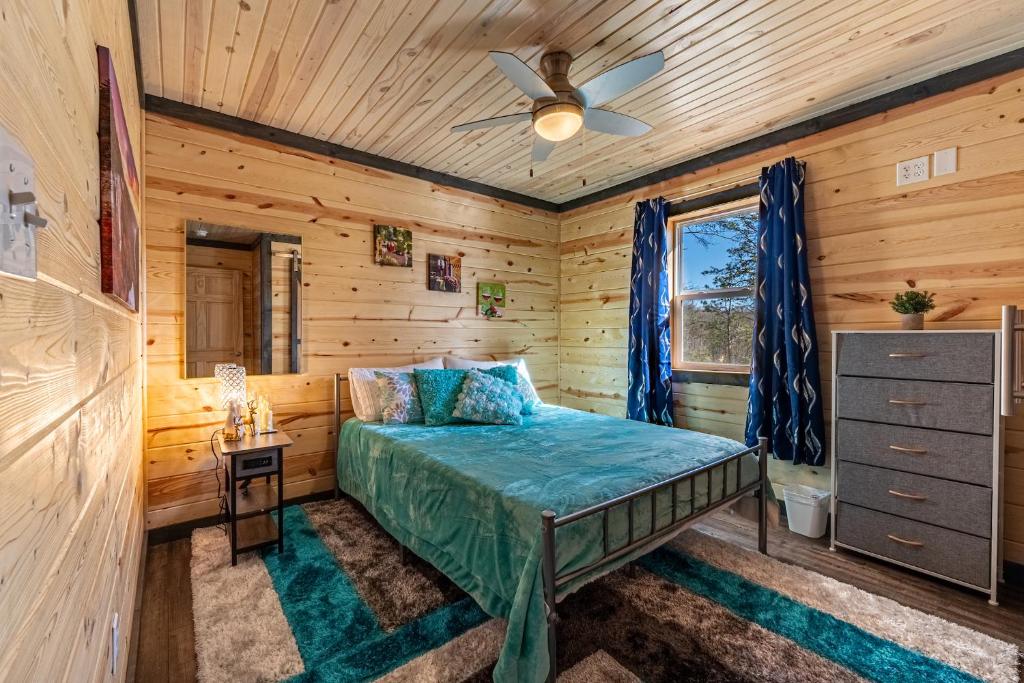 a bedroom with a bed and a ceiling fan at Wooded Circle - Barrel sauna, hot tub, fire pit in Hico