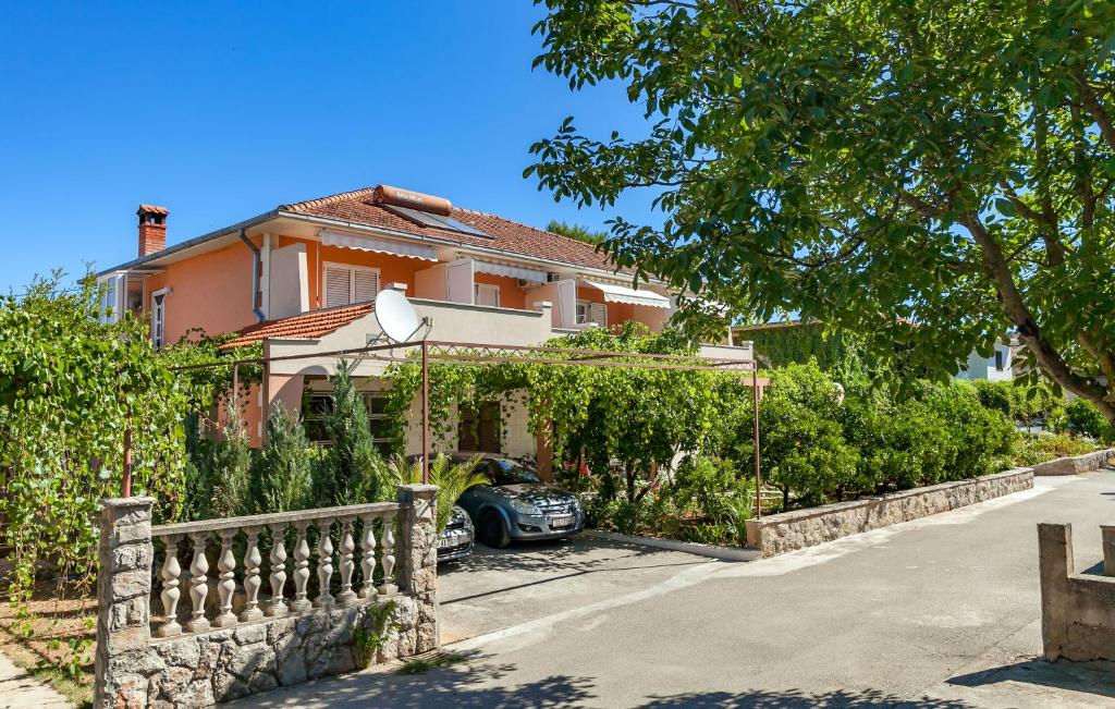 a house with a car parked in front of it at Apartments and Rooms Dobrila in Jelsa