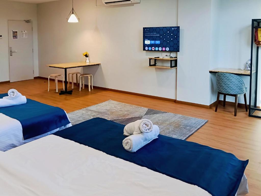 a living room with two beds and a table at KM Barakah Suite in Kuala Terengganu